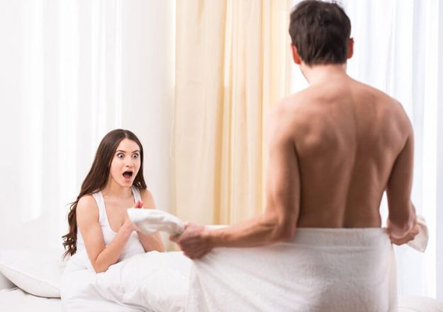 surprised woman as man takes off towel