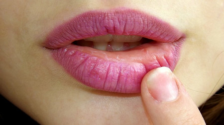 photo of a finger seductively touching a woman's lips