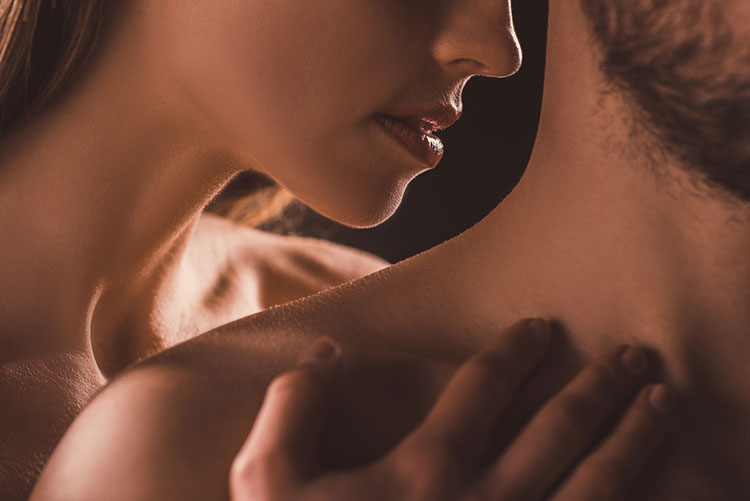 woman kissing man's neck in a tantric session